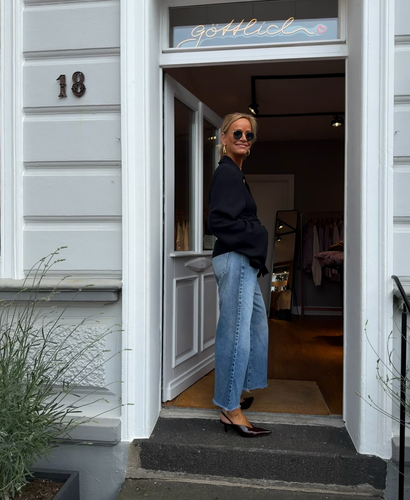 Schwarze Bluse mit Denim vor dem Store